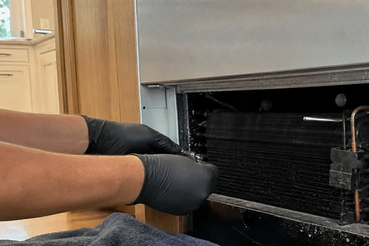 Frost buildup coating the interior walls and evaporator coil of a Sub-Zero freezer in a Woodside home